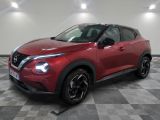 un SUV Nissan rouge garé sur un sol à damier dans un garage