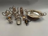 silver plated tea and coffee set with silverware on a table