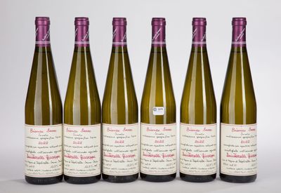 six bouteilles de vin sont alignées sur une surface blanche