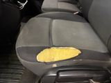 a dirty seat in the back of a car with a hole in it
