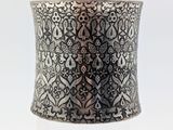 a close up of a silver cuff bracelet on a white background