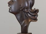 sculpture d'une tête de femme sur une base en bois