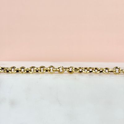 a close up of a gold chain bracelet on a marble surface