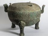 un vieux bol en bronze orné de sculptures, posé sur une table