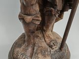 bronze statue of a man with a cane and a hat on a pedestal