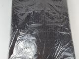 un gros plan d'un sac en plastique noir posé sur une surface blanche