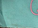 a pink cat sitting on top of a blue bag