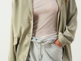 an image of a woman wearing a green jacket and jeans