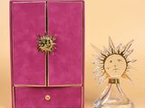 purple box with a gold sunburst and a glass candle holder