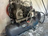 a small air compressor sitting on the floor in a garage