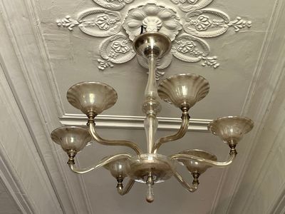 a silver chandelier hanging from the ceiling in a room