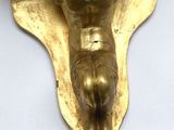 a gold statue of a man on a cross on a wall