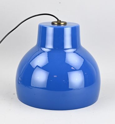 une image représentant une lampe bleue posée sur une surface blanche