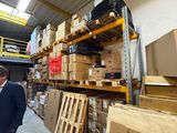 un homme debout dans un entrepôt, entouré de cartons