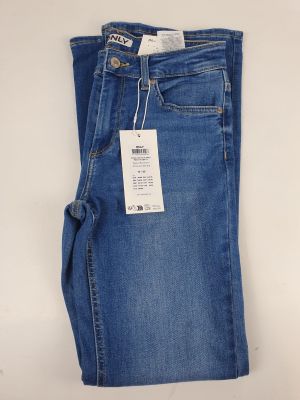 un gros plan sur un jean bleu posé sur une surface blanche
