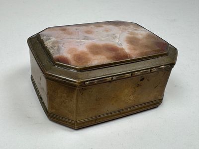 a small metal box with a stone inside of it
