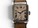une montre en argent avec des chiffres romains sur le cadran