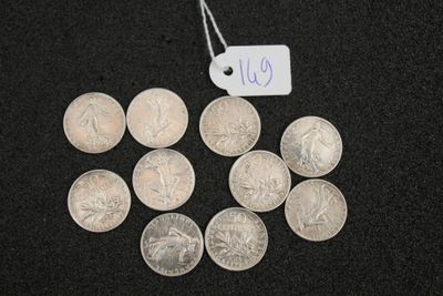 several silver coins sitting on a black surface with a price tag