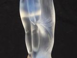 une photo d'une figurine en verre représentant une femme, posée sur un socle en bois