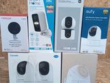 four boxes of smart home cameras sitting on top of a wooden table