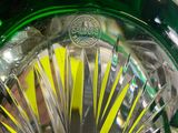 a close up of a green glass bowl with a yellow stripe