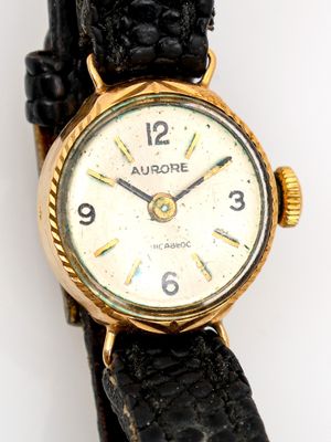 une image d'un gros plan d'une montre-bracelet sur une surface blanche