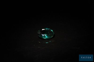 un gros plan d'une émeraude verte sur une surface noire