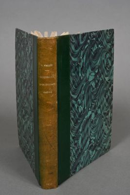 an old book with a green cover sitting on top of a table