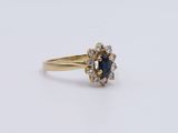 a close up of a gold ring with a sapphire and diamonds