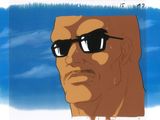 une photo représentant un homme portant des lunettes de soleil, avec un ciel bleu en arrière-plan