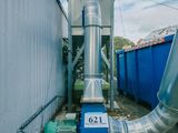 un gros tuyau situé à côté d'un conteneur bleu