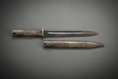 two knives are sitting side by side on a gray surface