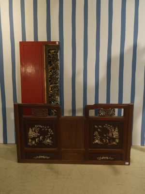 une armoire en bois surmontée d'un miroir, placée devant un mur rayé de bleu et de blanc
