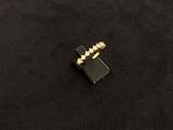 a close up of a black and gold ring on a black surface
