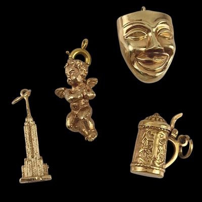 three gold - plated items including a mug, a statue, a statue of liberty and a statue of
