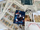 a pile of old books and postcards on a bed