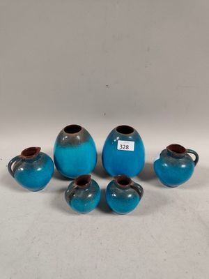 six small blue vases and two smaller blue vases on a white surface