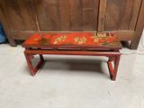 a small red table with a floral design on it
