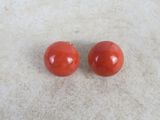 a pair of red coral earrings on a white surface