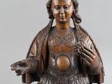 une statue antique en bronze représentant une femme les mains tendues