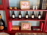 bottles of wine and bottles of wine sit on a shelf in a room