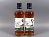 deux bouteilles de whisky posées l'une à côté de l'autre sur une table