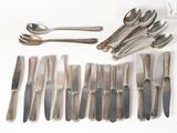 un grand nombre de cuillères et de fourchettes disposées sur la table