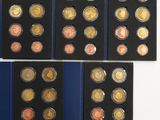 a group of six different coins in a display case