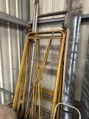 un tas de tuyaux métalliques et d'échelles dans un entrepôt