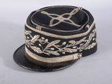 un chapeau noir orné de broderies dorées sur fond blanc
