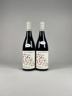 two bottles of red wine sitting next to each other on a table