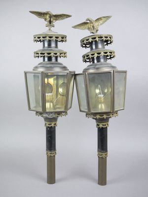 pair of brass and glass street lamps with eagle heads on top