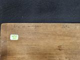 a piece of wood with writing on it on a black surface