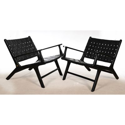 une paire de fauteuils de salon en cuir noir avec des coussins en cuir noir